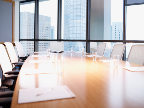 Empty boardroom table with paperwork